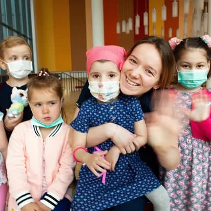 Изображение детей рядом взрослыми людьми волонтерами